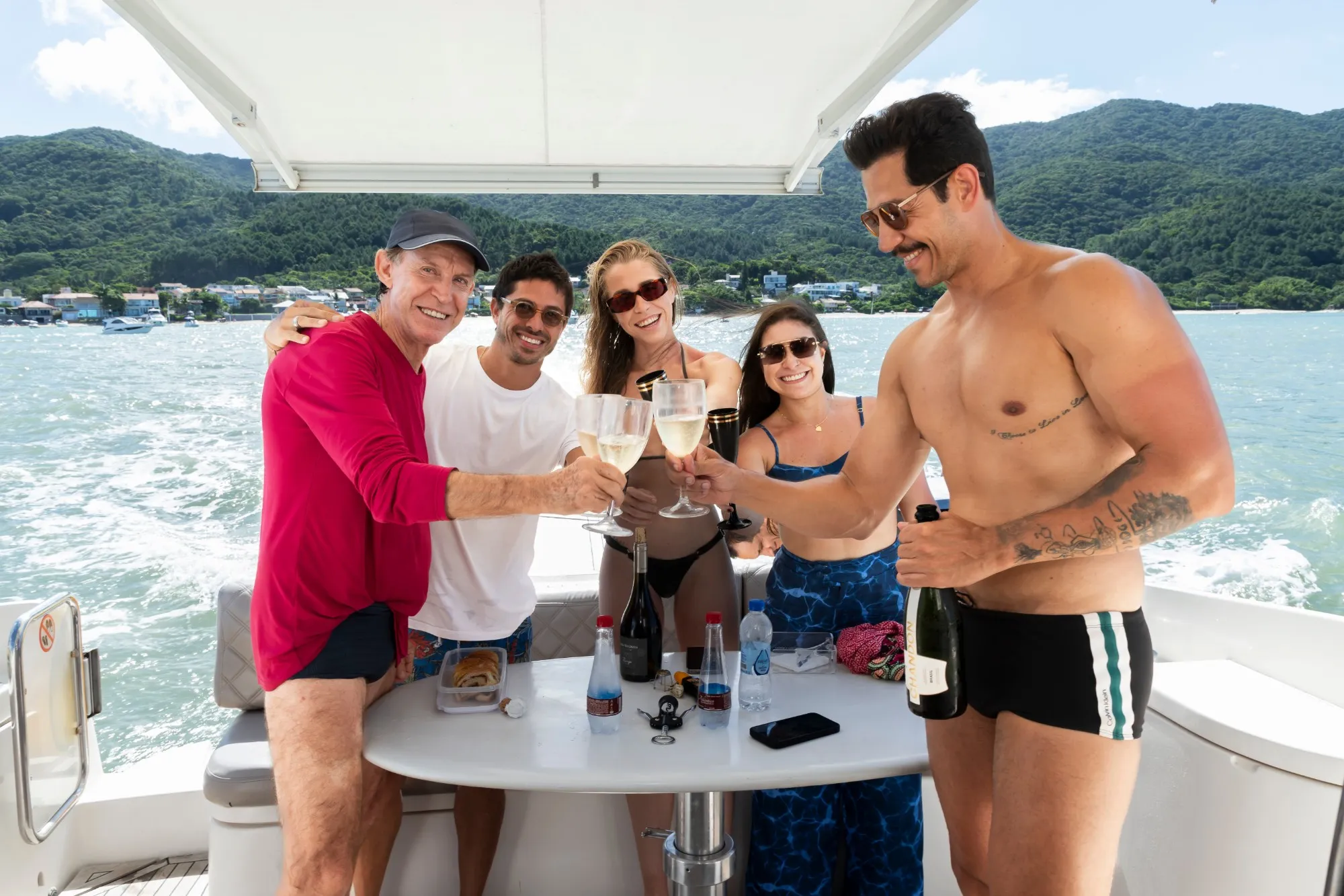 Friends toasting with sparkling wine around a table on deck