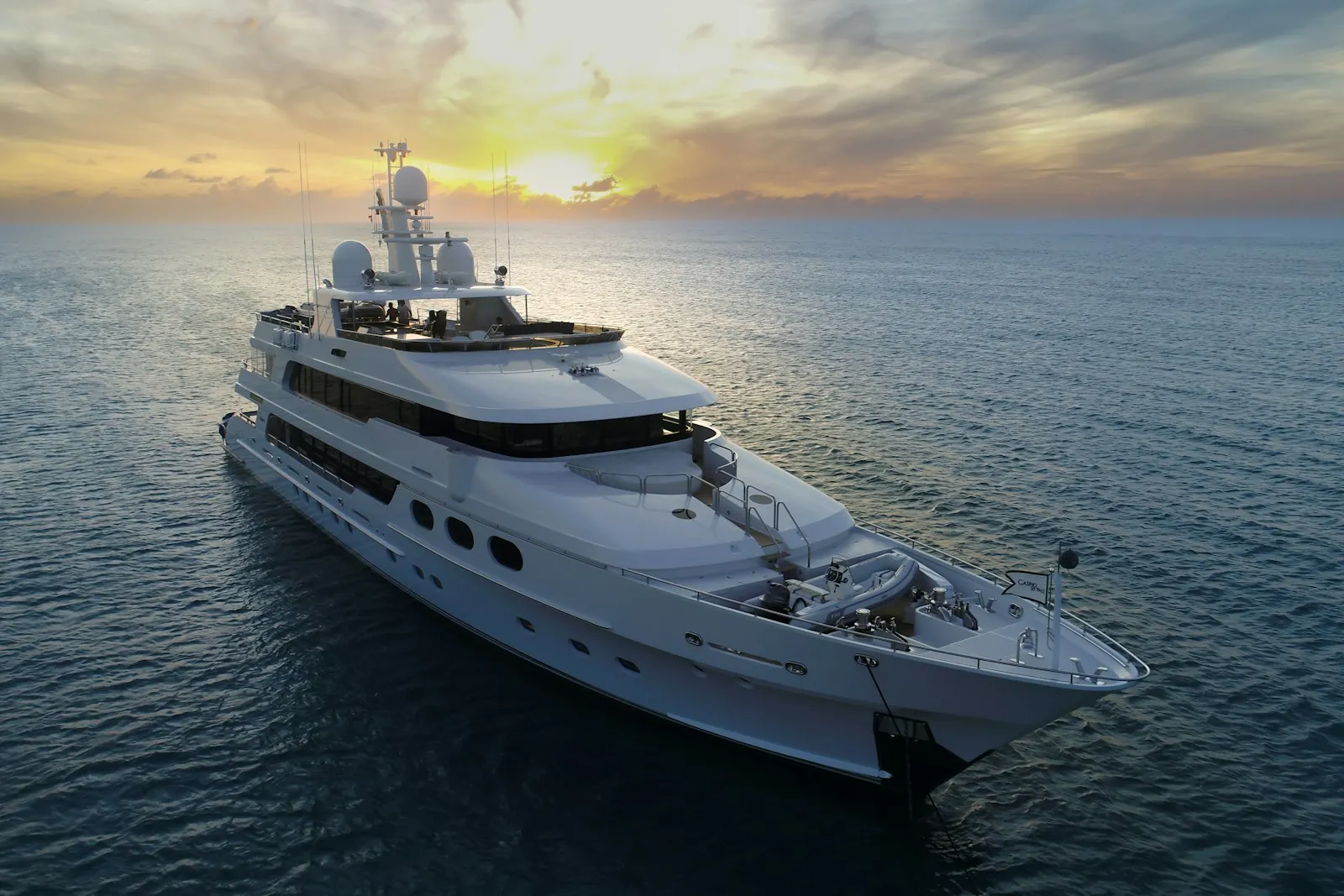 A yacht at sea under a golden sunset sky